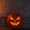 Scary laughing pumpkin and old skull on ancient gothic fireplace. Halloween, witchcraft and magic.