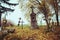 Scary leaning cross tomb stones in a foggy autumn scene in fall. Old creepy graves on cemetery in Slovakia. Spooky aged tombstones