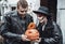 Scary love family couple man,woman celebrating halloween with pumpkin jack-o-lantern.Terrifying black skull half-face