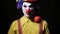 Scary mad Juggler clown using juggling pins. Terrible horror clown.