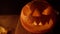 Scary pumpkin on Halloween close-up in smoke with flickering candle light from his eyes