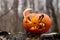 Scary pumpkin with tongues of flame in a dense forest. Jack o lantern for halloween