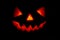 Scary smiling glowing pumpkin lantern for halloween in the dark