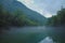 Scary spooky river of Kolpa on a gray dull summer day with clouds and overcast sky with thick fog above the water surface. Scary