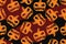 A scary terrifying orange pumpkin in a seamless dark pattern for the Halloween holiday with spots