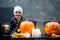 Scary toddler child in halloween costume, playing with carved pumpkins