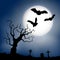Scary vector haloween landscape with a graveyard and flying bats in full moon.