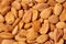 Scattered almond nuts on a brown background. Selective focus