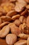 Scattered almond nuts on a brown background. Selective focus