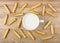 Scattered bread sticks, cup of milk on wooden table
