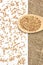 Scattered buckwheat grains. White background. Wooden spoon