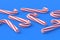 Scattered Christmas canes, candy with red stripes on blue background