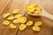 Scattered cornflakes, spoon with corn flakes on table