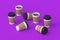 Scattered disposable paper coffee cups with black lid and sleeve