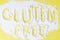Scattered flour on a yellow background with the inscription Gluten Free