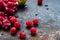 Scattered frozen red currants closeup lie on a rusty surface. copy space. horizontal