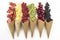 Scattered fruits strawberries, pineapple, raspberries, kiwi, blackberries, cherries in waffle, cone cups on a bright colored