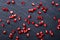 Scattered grains of ripe, ruby-colored pomegranate on black background