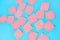 Scattered many pink square blank paper stickers on blue