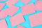 Scattered many pink square blank paper stickers on blue