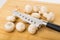 Scattered mushrooms and kitchen knife on cutting board