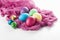 Scattered painted easter chicken and quail eggs on a white background with fuchsia gauze napkins