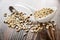 Scattered peeled sunflower seeds, seeds in spoon on wooden table