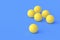 Scattered ping pong balls on blue background. Copy space