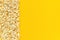 Scattered popcorn border left edge and empty space on yellow paper background. Top view Copy space Template for text or your