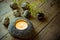 Scattered quail eggs on barn wood, spring yellow flowers, burning tea light candle