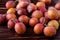 Scattered ripe sweet plum fruits on dark moody wood table background, soft light, copy space