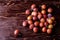 Scattered ripe sweet plum fruits on dark moody wood table background, soft light, copy space