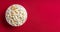 Scattered tasty cheese popcorn in bowl isolated on red background with copy space