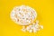Scattered tasty cheese popcorn in bowl isolated on yellow background