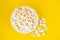 Scattered tasty cheese popcorn in bowl isolated on yellow background