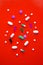 scattered various colored tablets in a red background. View from above. close-up