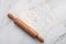 Scattered wheat flour and rolling pin set up on white marble background flat lay