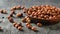 Scattered on a wooden table and in a clay bowl hazelnuts. Vegetarian cuisine