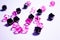 A scattering of beads on a white background, a sheet. Crystals. Iridescent and shiny pink and black beads. Materials for needlewor