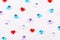 A scattering of colored glass hearts on white background for Valentine`s Day