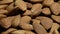 A scattering of dried almonds on a dark background, a pile of nuts, camera movement, selective focus.