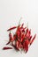 A scattering of hot chili peppers top view on a white background vertical orientation