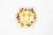 A scattering of many small different fruits on a white background. Emoji cheerful smile.