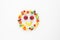 A scattering of many small different fruits on a white background. Emoji cheerful smile.