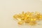 A scattering of transparent yellow omega-3 capsules