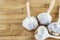 Scattering of whole head of garlic on a light beige wooden background