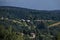 Scene with autumn meadow, forest and residential district of the Bulgarian village of Plana in the Plana mountain