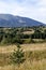 Scene with autumn meadow, forest and residential district of the Bulgarian village of Plana in the Plana mountain