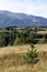 Scene with autumn meadow, forest and residential district of the Bulgarian village of Plana in the Plana mountain