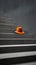 Scene in conceptual minimalist style of orange hat on stairs steps.